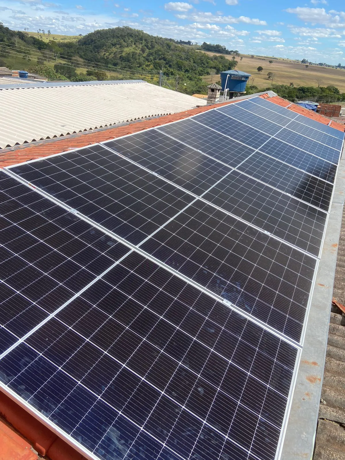 Módulos fotovoltaicos alinhados sobre a água principal do telhado