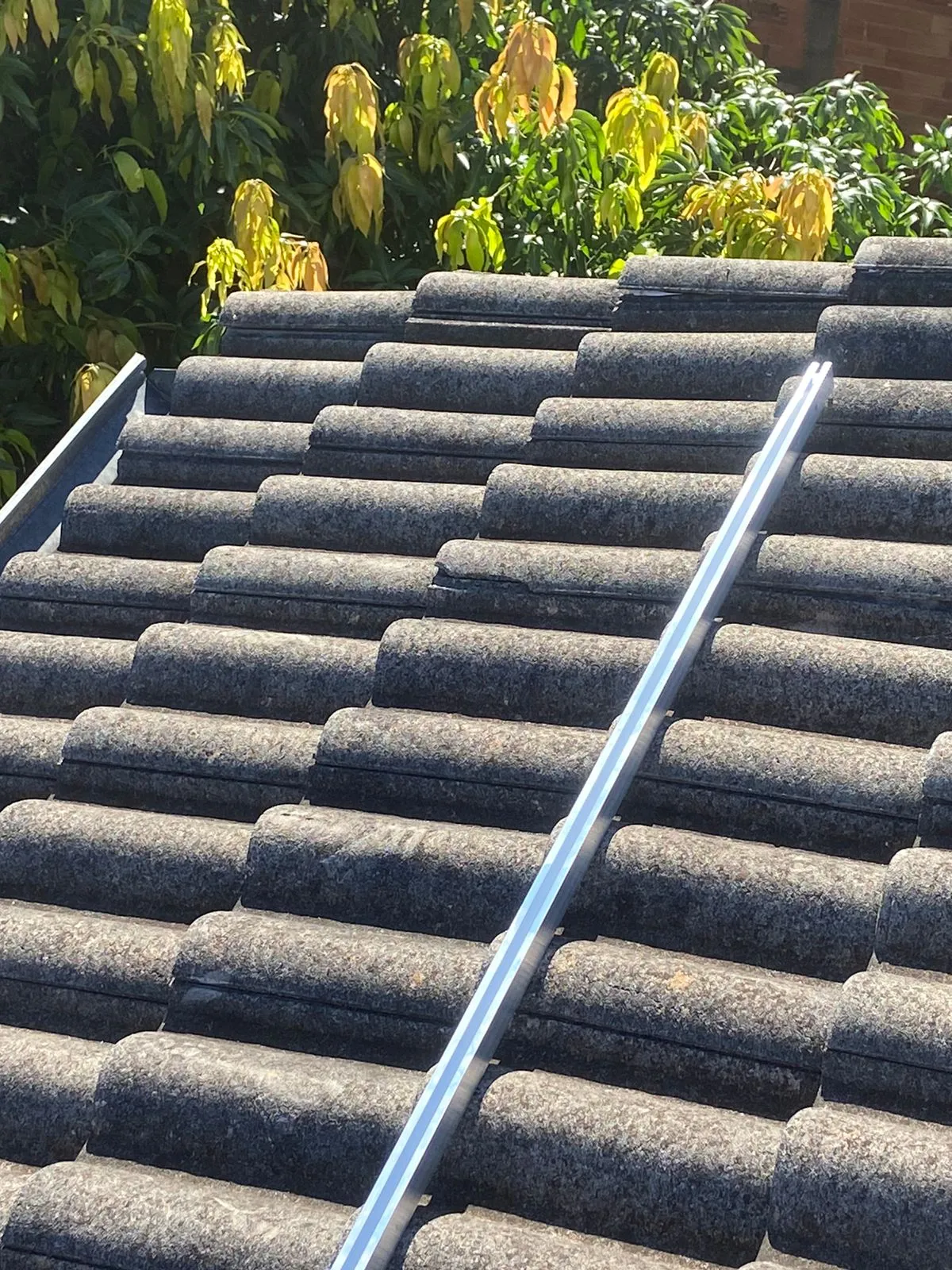 Trilho de fixação instalado sobre telha de concreto antes dos módulos
